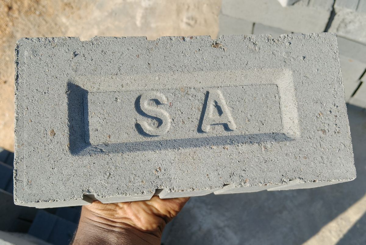 Close-up of a concrete brick stamped SA